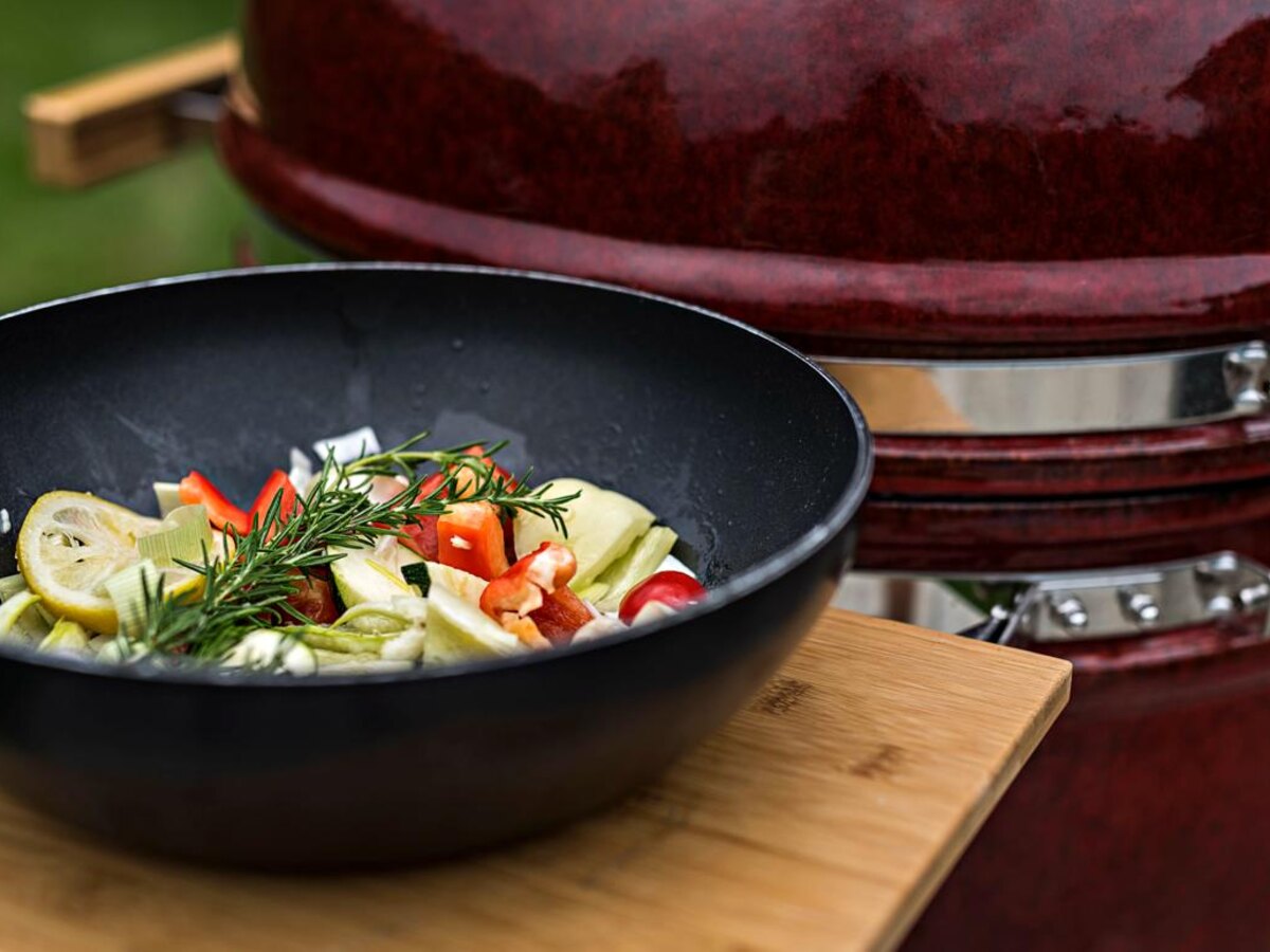 A wok of fresh vegetables on a Kamado Chef